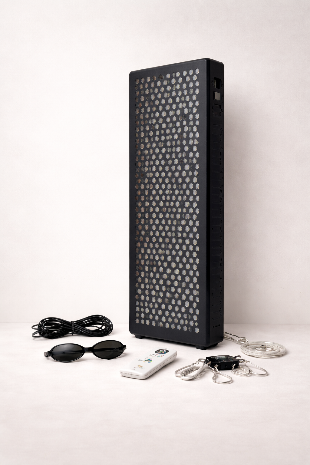 Black rectangular light therapy device with accessories on a white background